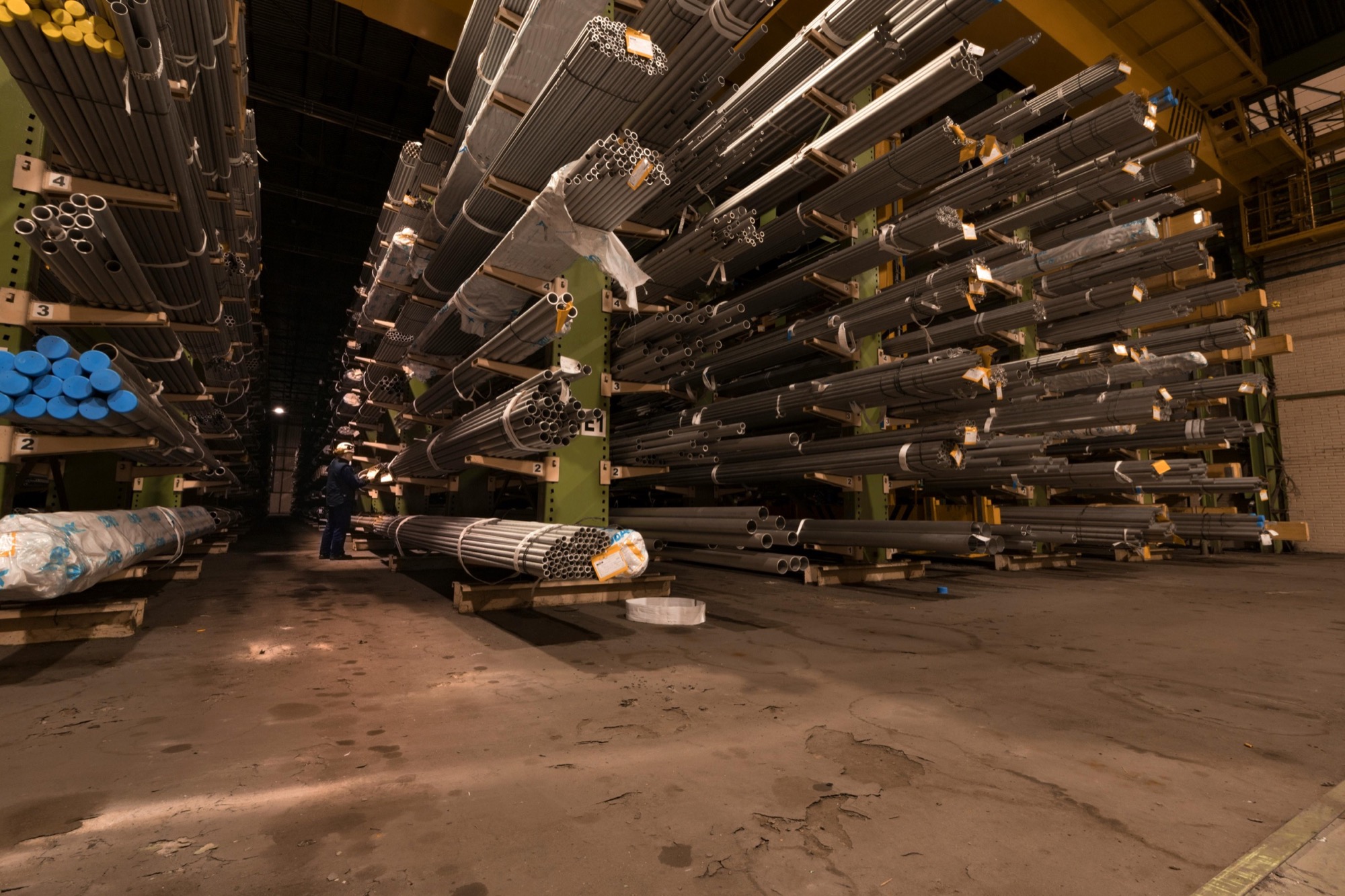 Industrial pipe warehouse with steel pipes stacked on storage racks